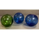 Three vintage glass fishing floats, one green and two cobalt blue