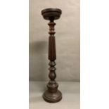 A large turned mahogany candle holder