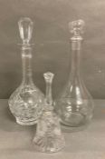 Two glass decanters and a cut glass bell