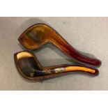 An antique pipe with amber stem and silver mount.