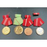 A selection of four East German medals, cased.