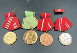A selection of four East German medals, cased.