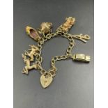 A 9ct gold charm bracelet with a selection of charms to include cars, slipper on a heart shaped