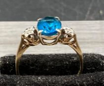 A 9ct gold ring with blue central stone, diamond shoulders. (Approximate Total Weight 1.7g) Size K