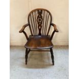 A dark oak wheel back arm chair