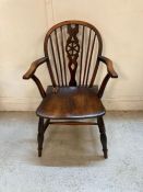 A dark oak wheel back arm chair