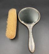 A hallmarked silver backed dressing table mirror and brush
