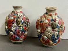 A pair of porcelain snuff bottles with the eighteen lochans immortals in raised relief marked at