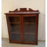 A mahogany two door bookcase with glass front