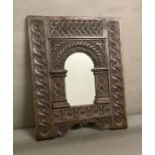 A wooden carved wall mirror with floral and scrolling detail 49x61