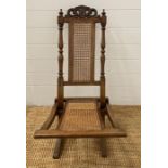 A Victorian folding steamer chair with cane seat and back
