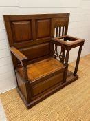 An oak hall stand with panelled seat opening to storage and flanked by a stick stand (H115cm