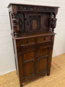 An oak side cabinet with turned supports and cupboard under (H137cm W71cm D38cm)