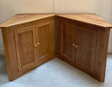 A pair of pine two door corner cabinets (H77cm W93cm D51cm)