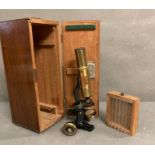 A boxed vintage microscope with glass slides