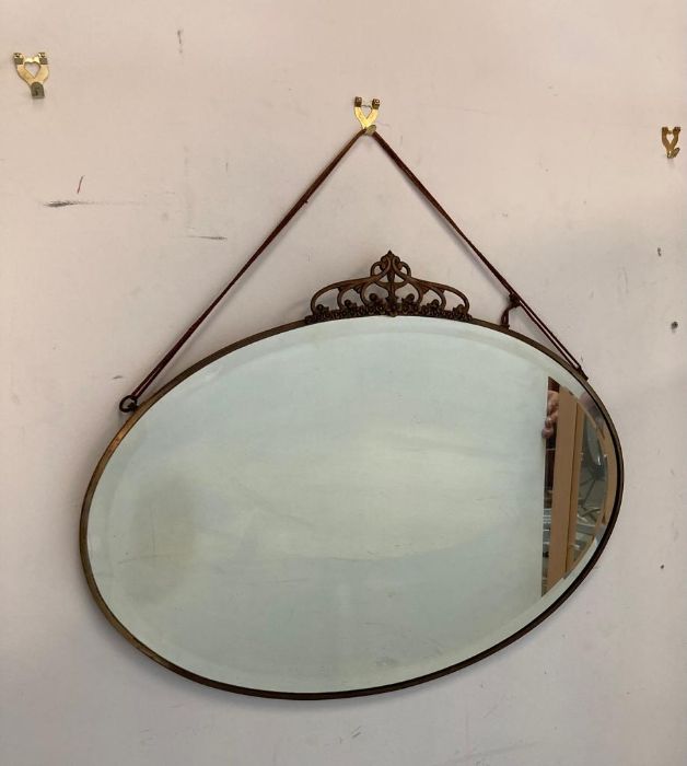 An oval brass framed Arts and Crafts style bevel edged mirror