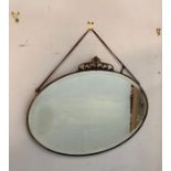 An oval brass framed Arts and Crafts style bevel edged mirror