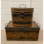 A vintage black and gold metal hat box and chest painted with floral motif