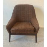 A Mid Century Parker Knoll arm chair upholstered in browns and blacks