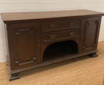 An Arts and Crafts style sideboard, two central drawers flanked by cupboards on square turned