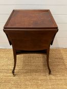 A mahogany side table with hinged sides on down swept legs and castors (H69cm W52cm D48cm)