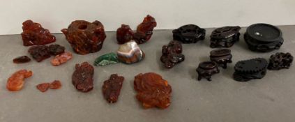 A collection of miniature carved figurines and stands, possibly amber