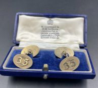 A boxed pair of Garrard and Co Gents silver cuff links with '35' on them.