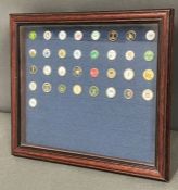 A framed collection of golf ball markers