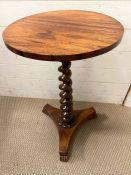 A circular side table on barley twist centre support, finish on a raised tri-form base (H70cm