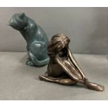 A sculpture of a cat and bronze effect lady
