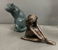 A sculpture of a cat and bronze effect lady