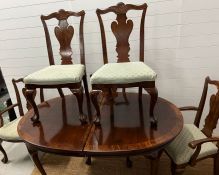 A mahogany extending dining table with two leaves, on ball and claw feet along with two carvers