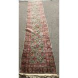 A pink and green runner rug 348cm x 72cm