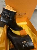 A pair of black Tod's boots with one buckets