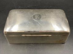 A silver engine turned cigarette box, top engraved with the letters R/K within a Cartouche,