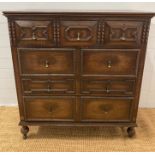 An oak Jacobean style three over three chest of drawers with central drop down front (H110cm