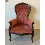 A victorian button backed lounge chair upholstered in salmon pink