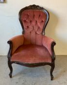 A victorian button backed lounge chair upholstered in salmon pink