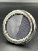 A small round silver picture frame, indistinct hallmarks, approximately 8cm diameter, easel back.
