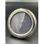 A small round silver picture frame, indistinct hallmarks, approximately 8cm diameter, easel back.