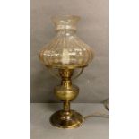 A converted brass oil lamp with iridescent glass shade height 44cm