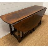 A large drop leaf table on turned legs (160 cm x 153cm max)