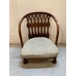 An Arts and Crafts nursing chair with grey upholstered cushion