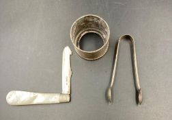 Three silver items to include, sugar nips, napkin ring and a mother of pearl handled fruit knife.