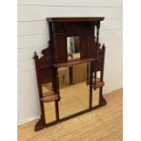 An Edwardian wall mirror, with display shelves to sides on turned supports (129cm x 90cm)