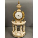 A white marble and brass shelf clock supported by marble pillars and brass accents