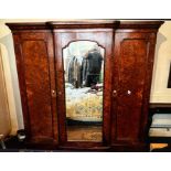 A Victorian burr walnut triple wardrobe. A breakfront shape top cornice above three doors, two