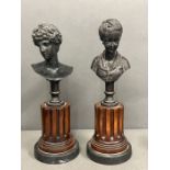 A pair of bronze busts of a Greek god and a lady on column plinth H31cm
