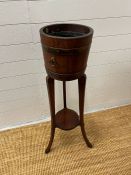 A plant stand in two pieces in the form of a brass bound barrel on splayed feet