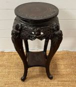 An ebonised plant stand table, carved with leaves and flowers (H73cm)